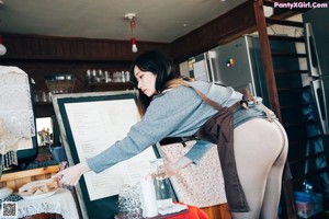 A woman sitting on top of a table next to a window.