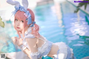 A woman in a bunny costume floating in a pool.