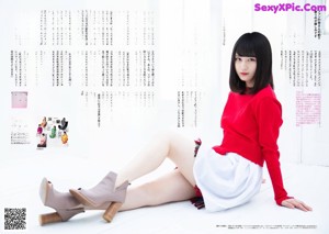 A woman in a red sweater is posing for a picture.
