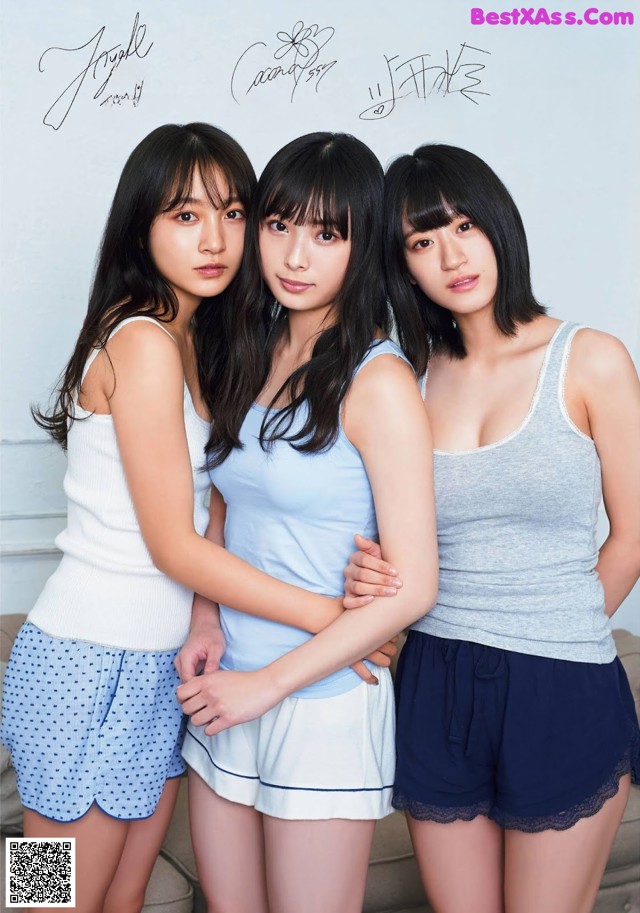 A group of three young women standing next to each other.