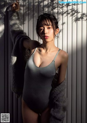 A woman in a blue bra and panties in a bathtub.