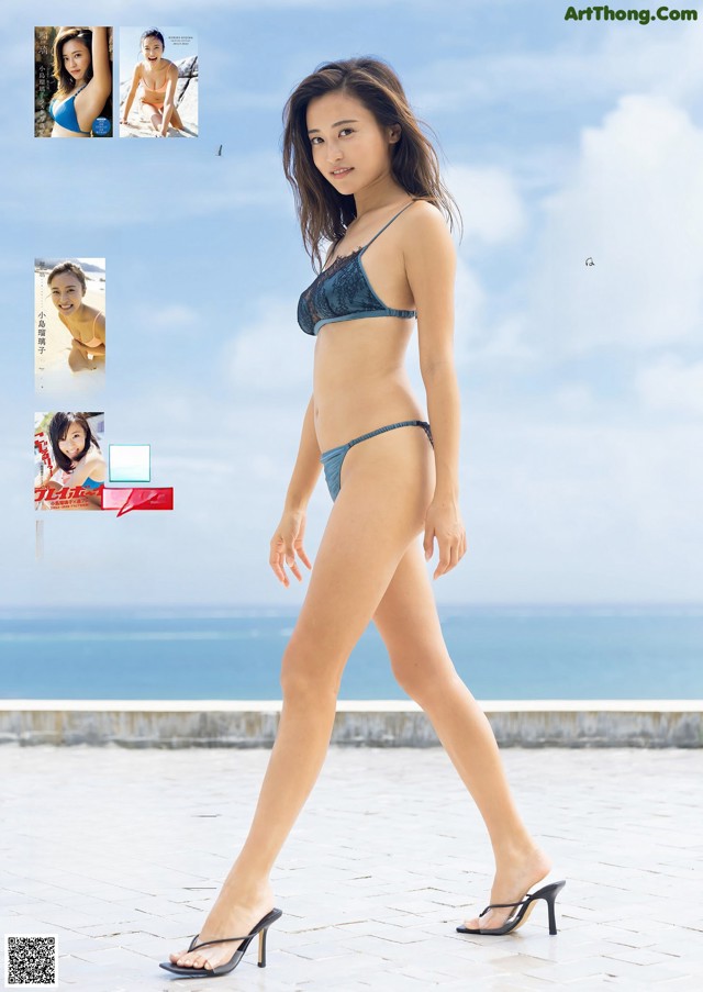 A woman in a blue bikini standing on a beach.