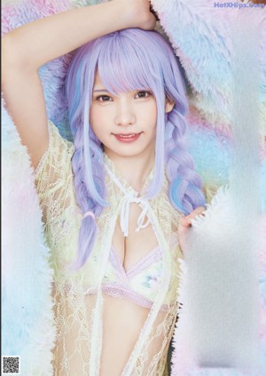 A woman with long purple hair is posing for a picture.