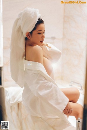 A woman in a white shirt is standing in a shower.