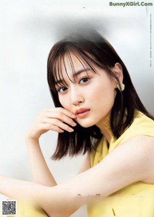 A woman in a yellow dress posing for a magazine.