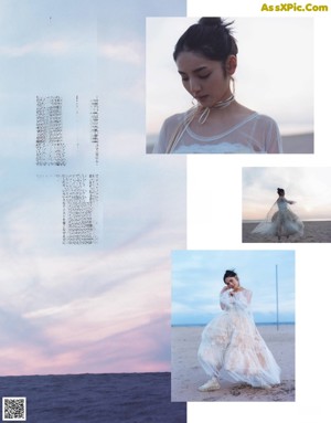 A woman in a white dress standing on top of a hill.