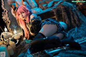 A woman with pink hair sitting on a couch.