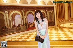 A woman in a black dress standing on a staircase.