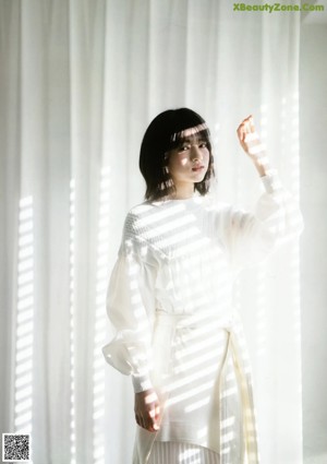 A magazine spread with a picture of a woman in a white dress.