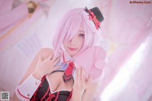 A woman in a pink and white outfit holding a pink heart.
