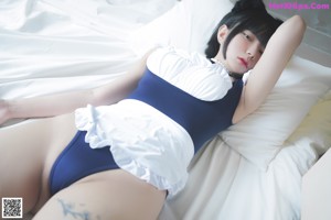 A woman in a blue and white dress sitting on a couch.